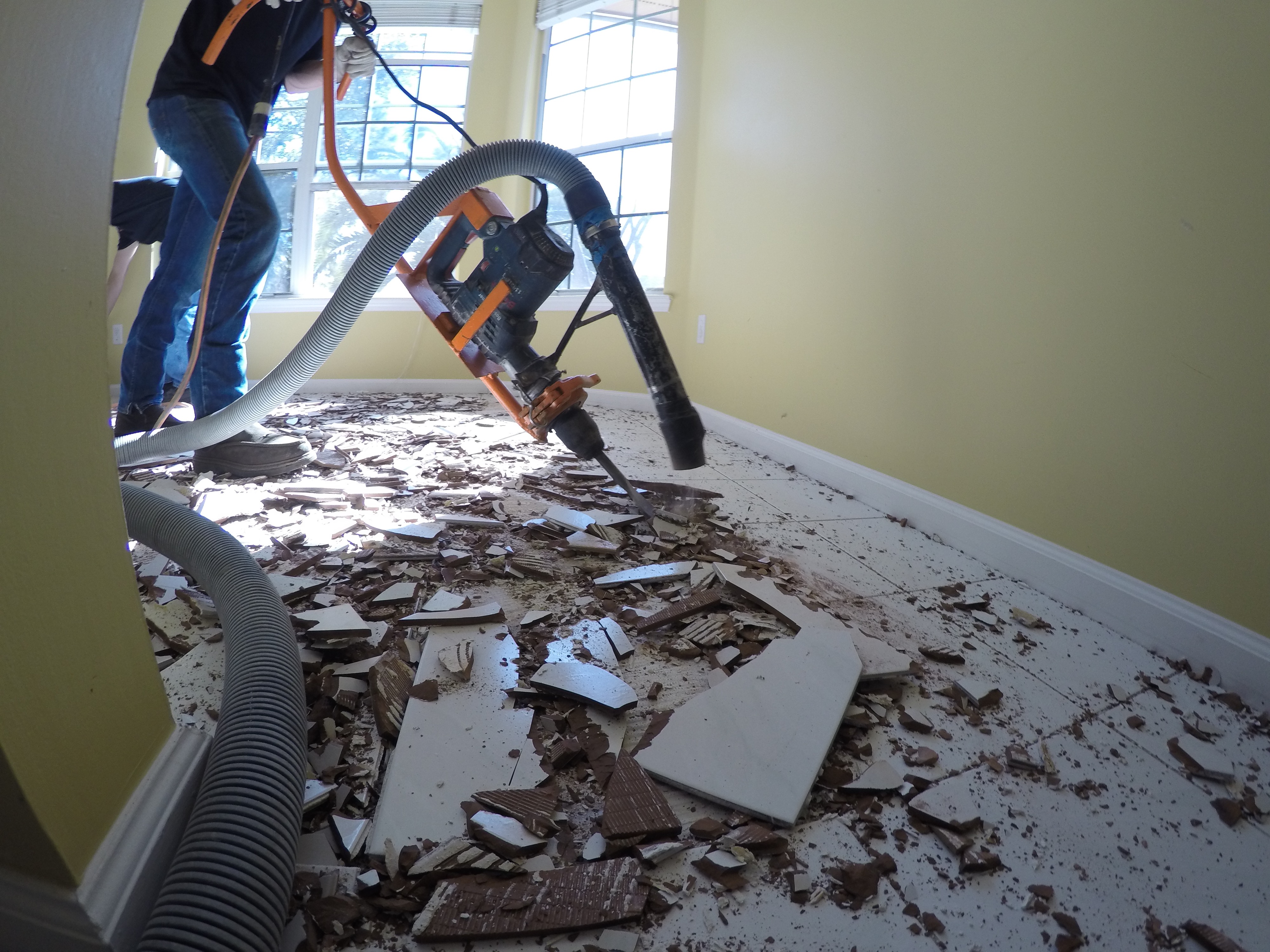 Close-up image of tile floor removal with suction machinery