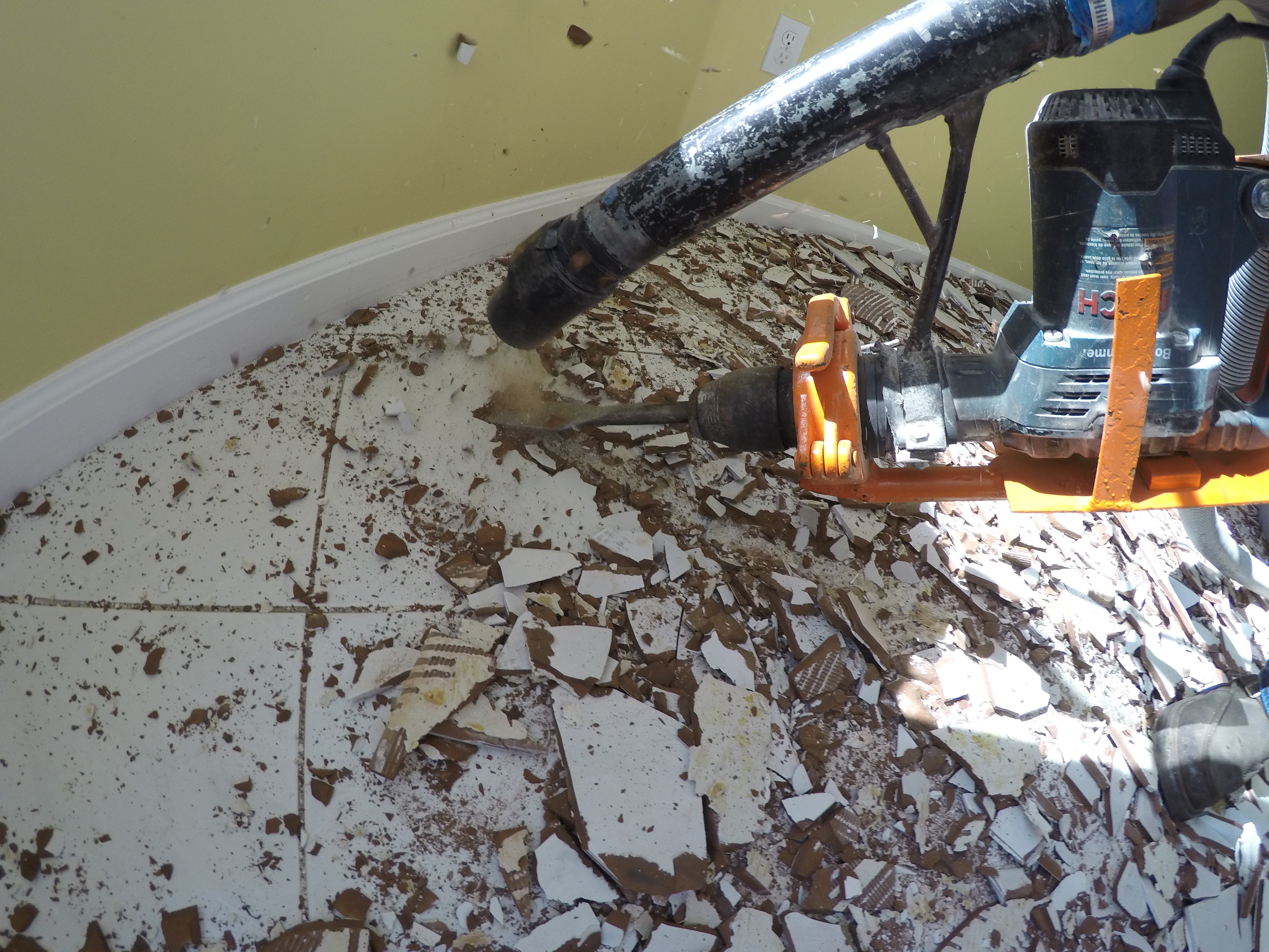 Image of tile flooring being broken up and removed